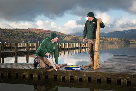 Two older holiday park employees working on maintenance 