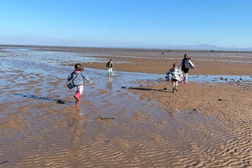 Family running along the beach