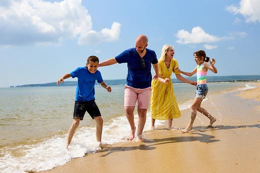 Family walking along the beach in the sunshine