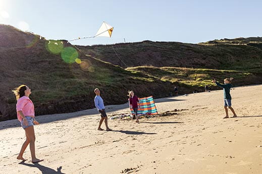 Family flying a kite on the beach