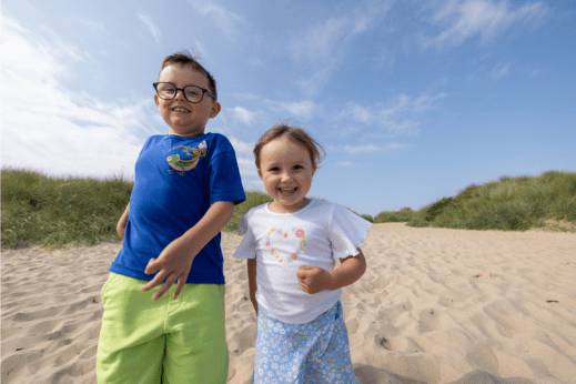 Kids running on a beach smiling