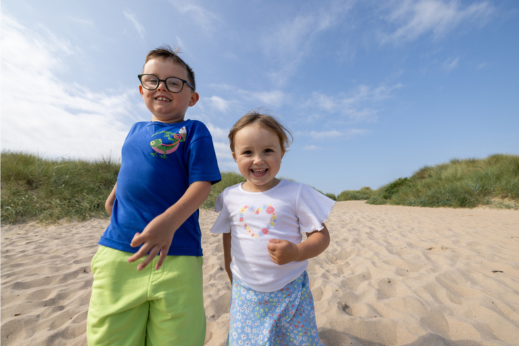 Kids running on a beach smiling