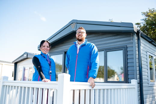 Two people standing on a caravan