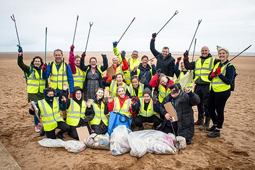 A group of people cleaning a beach