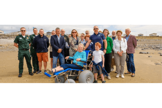 Group of people with a wheelchair on the beach