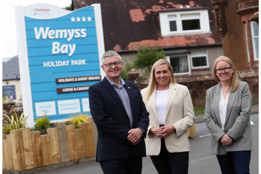 A group of three people stood outside of a holiday park