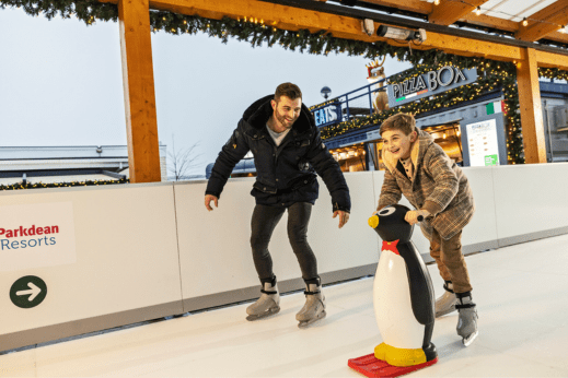 Family on ice rink with penguin aid
