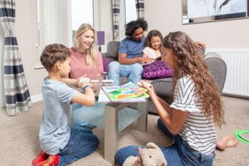 Family doing arts and crafts in caravan at Parkdean Resorts