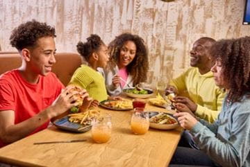 Family sat at a table eating and drinking