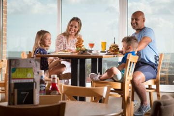 Family sat at a table eating and drinking