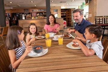 Family sat at a table eating and drinking
