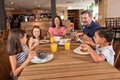 Family sat at a table eating and drinking
