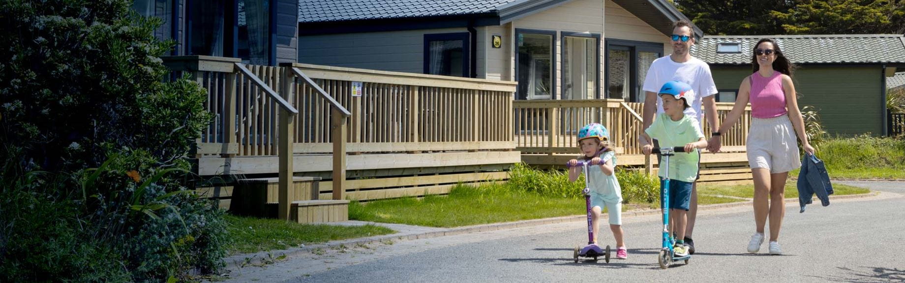 Family walking with children on scooters
