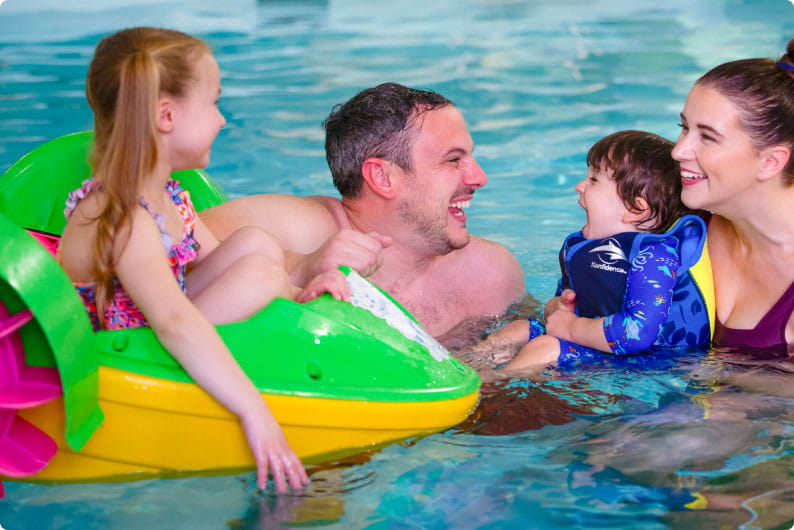 Family smiling in the indoor pool