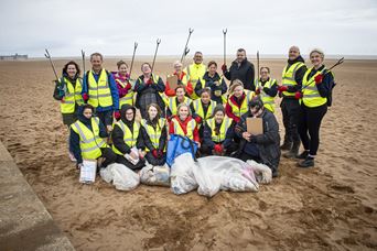 Group of people litter picking on a beach