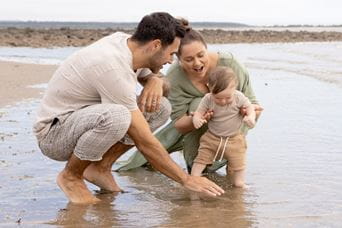 Family standing in the shallow sea