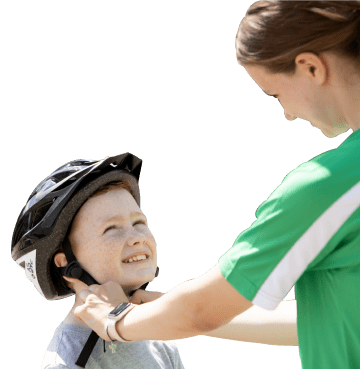 Mother putting a cycling helmet on her child