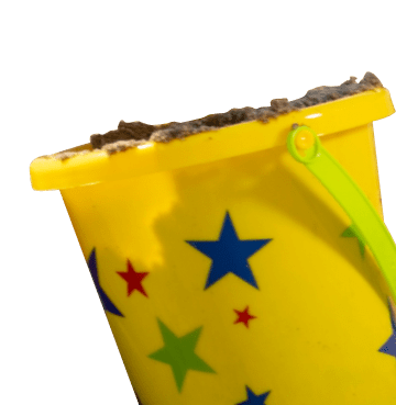 Yellow bucket filled with sand with blue green and red stars on the front