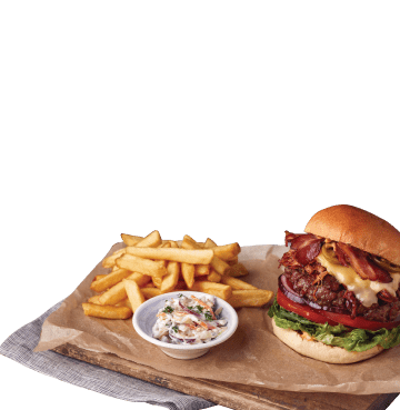 Cheeseburger and chips and coleslaw on a wooden board