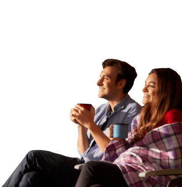 couple relaxing with hot drinks and blankets