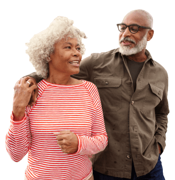Older couple walking arm in arm looking at each other