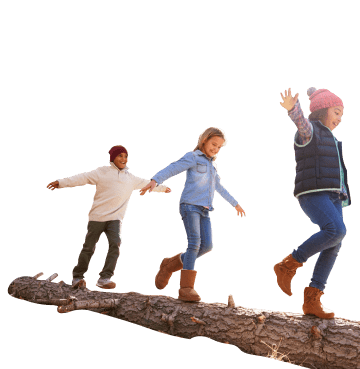 Three people wearing outdoor clothing walking along tree trunk