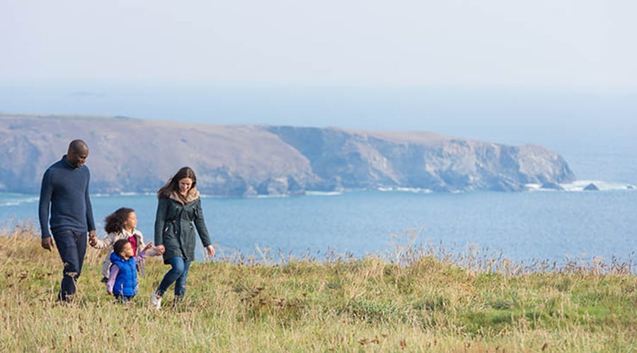 A family strolling on the grass by the sea