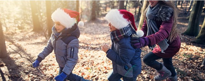 Kids running through the forest with Santa hats on