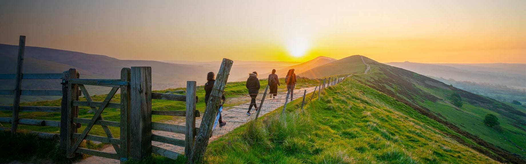 Hikers walking along a trail in the English hillside