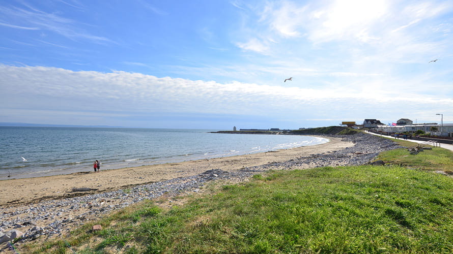 Trecco Bay Beach at high tide showing caravans near the sea