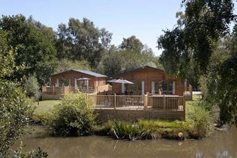 Lodges overlooking a pond on a holiday park in Dorset