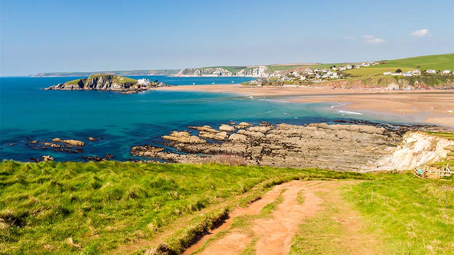 Surfers in the bay at Bantham Beach in Devon