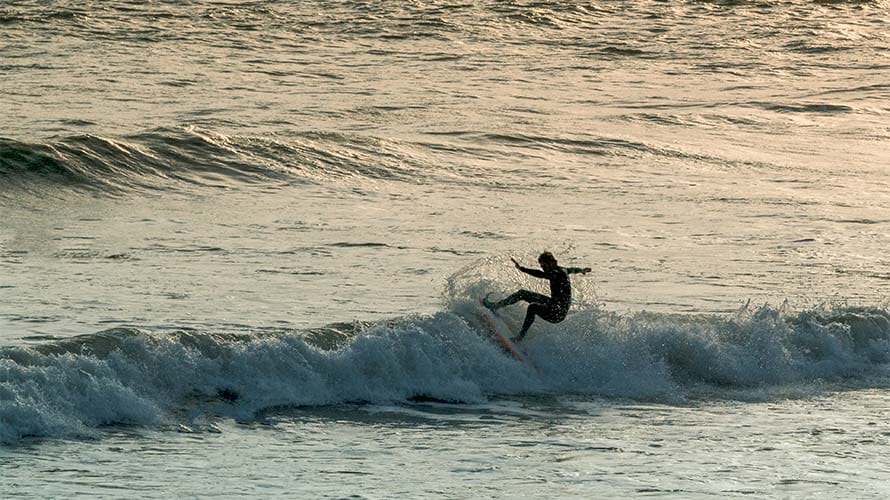 A surfer doing tricks on a wave in Wales