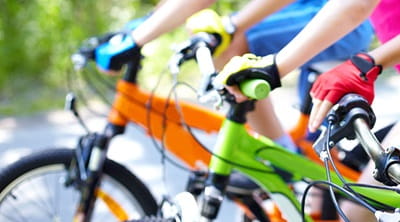 People gripping the handlebars of their bikes