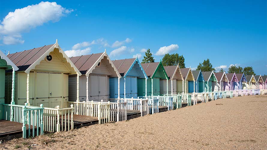 Colourful beach huts lining West Mersea Beach in Essex