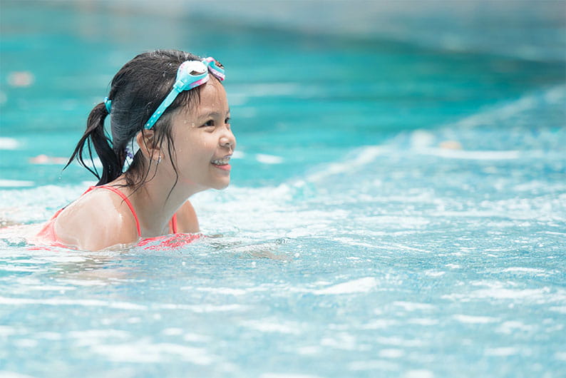 A girl swimming in an outdoor pool