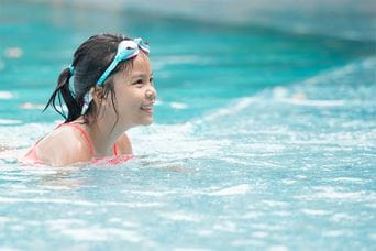 A girl swimming in an outdoor pool