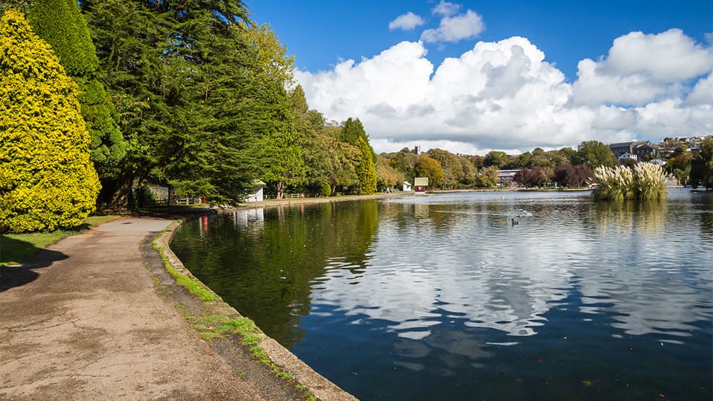 A peaceful boating lake surrounded by trees in Helston Cornwall