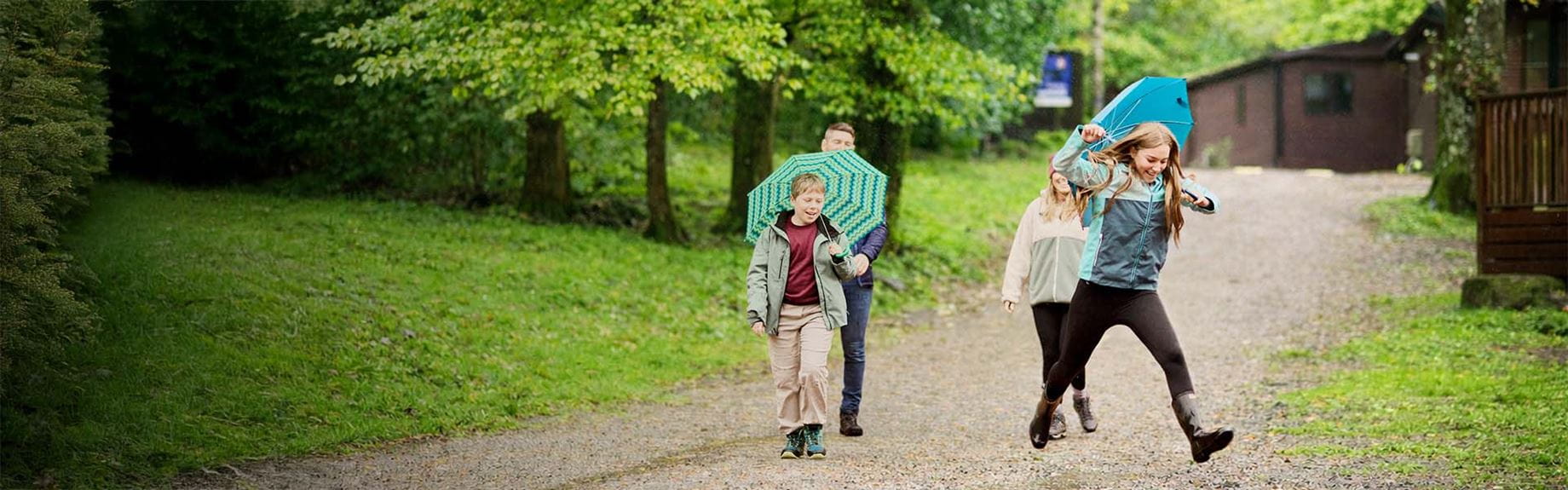 A family walking through a Parkdean Resorts holiday park in the rain