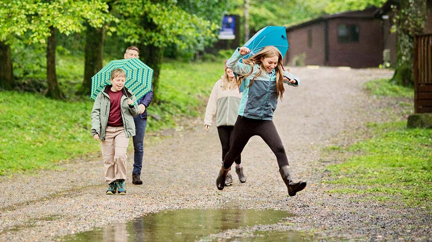A family walking through a holiday park on a rainy day