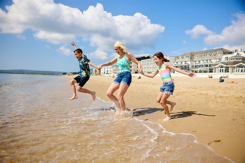 A family paddling in the sea on a sunny day in England