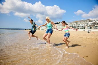 A family paddling in the sea on a sunny day in England
