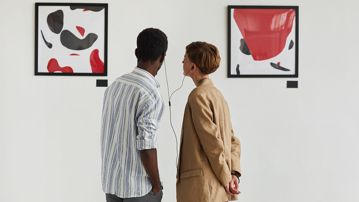 A couple listening to an audio guide in an art gallery