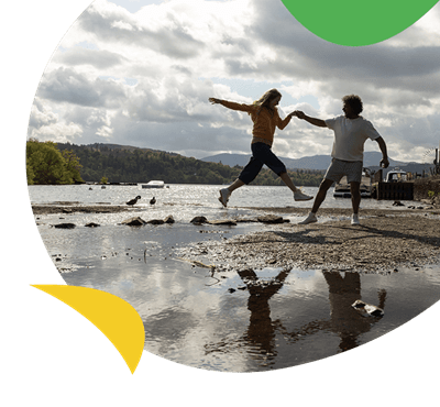 A couple jumping over a stream