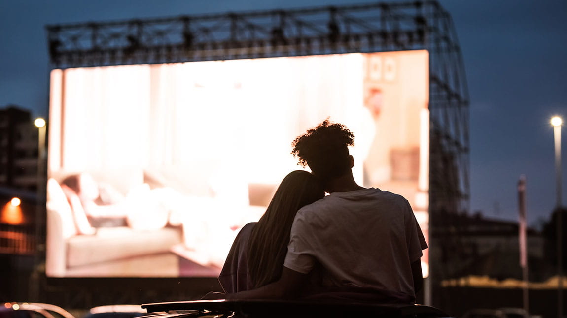 A couple watching a film at an outdoor cinema