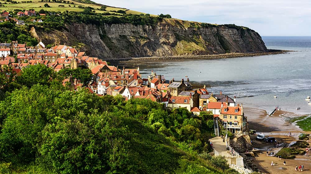 The village of Robin Hoods Bay with a view of the sea and cliffs