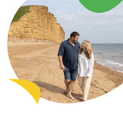 A couple walking along the beach in Dorset