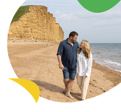 A couple walking along the beach in Dorset