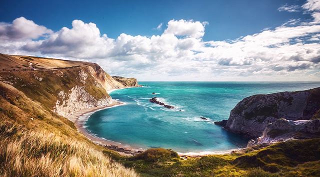A view over the blue waters of Lulworth Cove in Dorset
