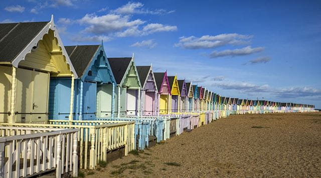 Rows of colourful beach huts lining a beach in Essex